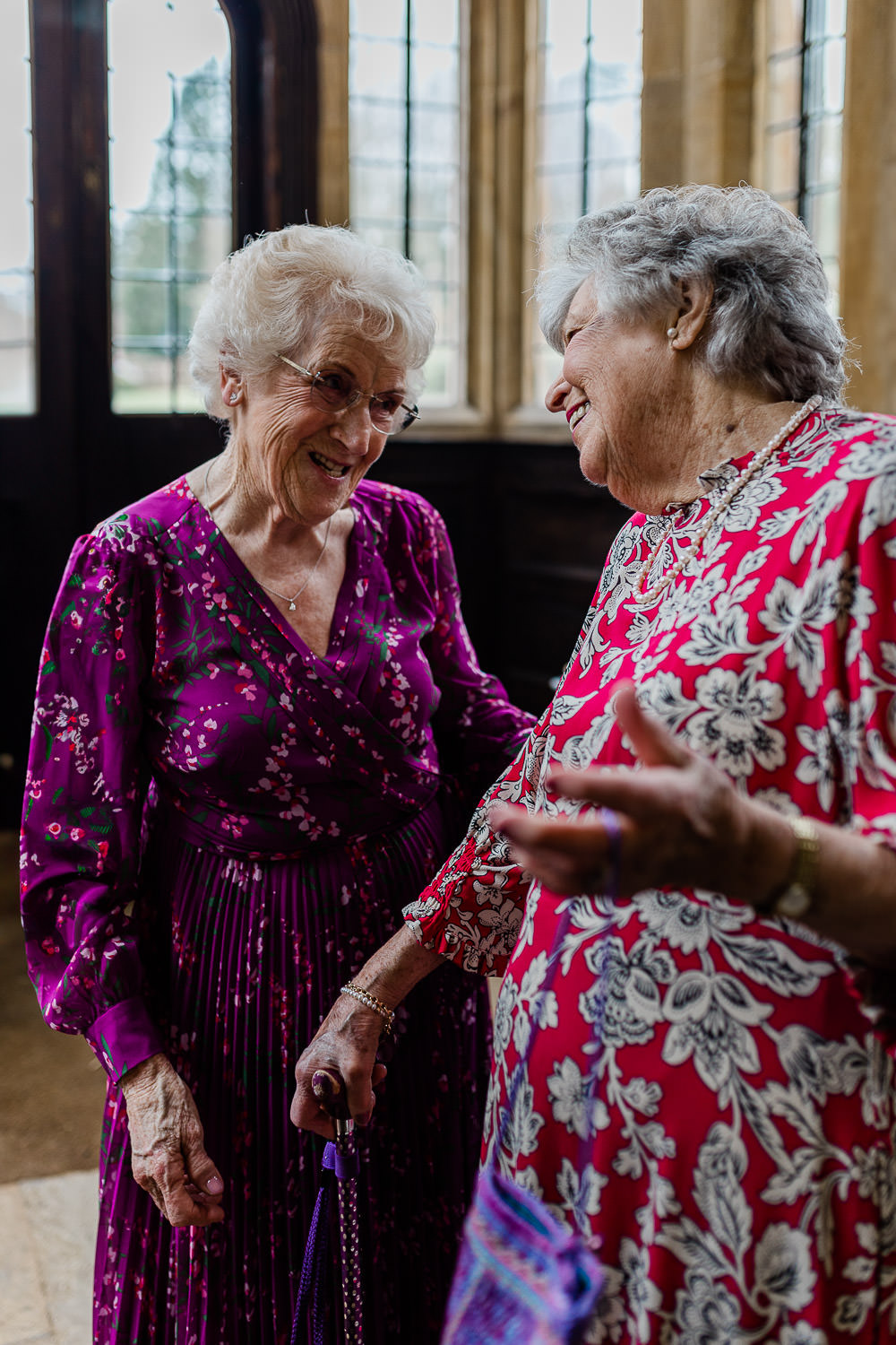 Older women laughing together, captured by documentary wedding photographer.