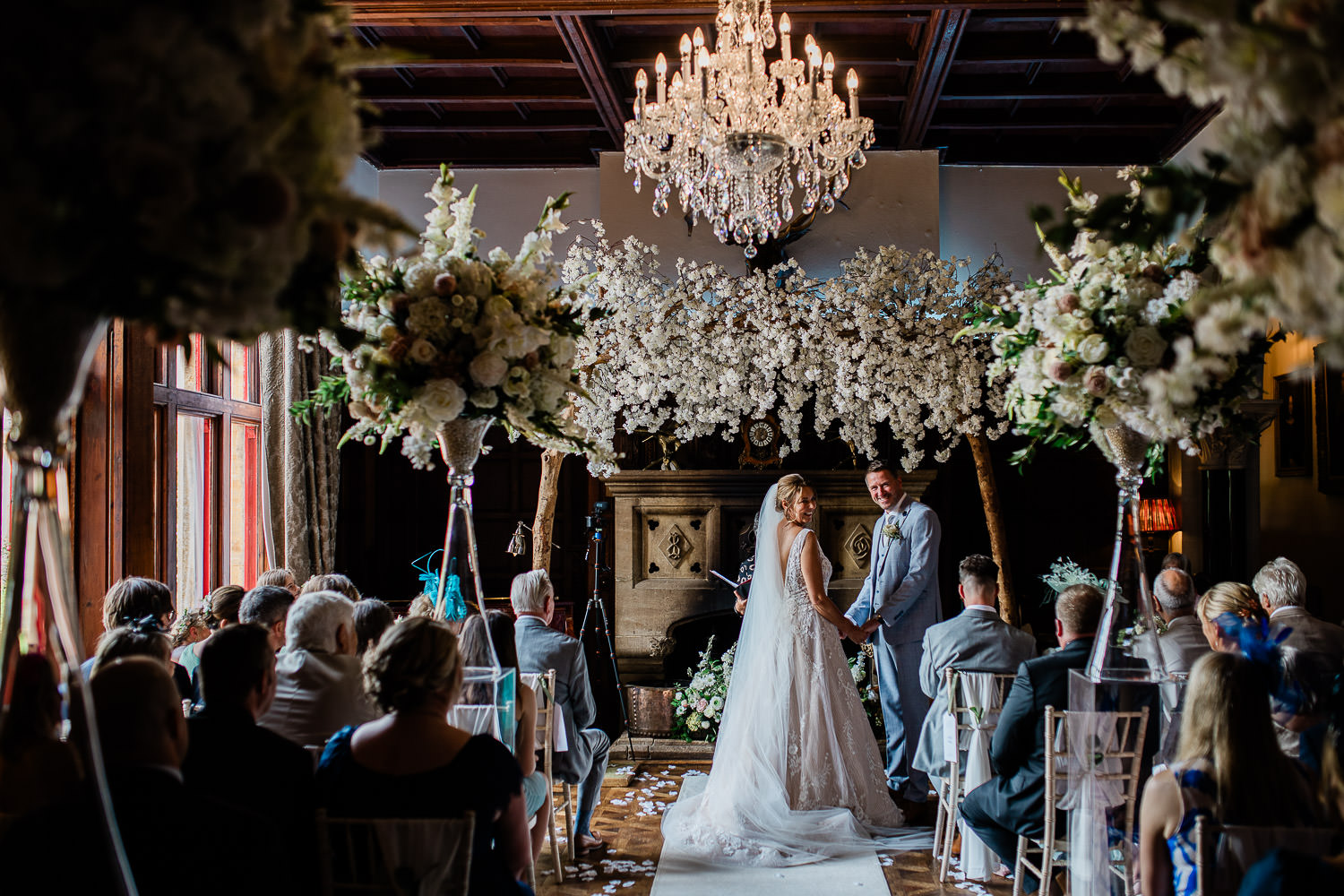 A bride and groom laugh during their wedding ceremony at Huntsham Court, captured by a wedding photographer Devon