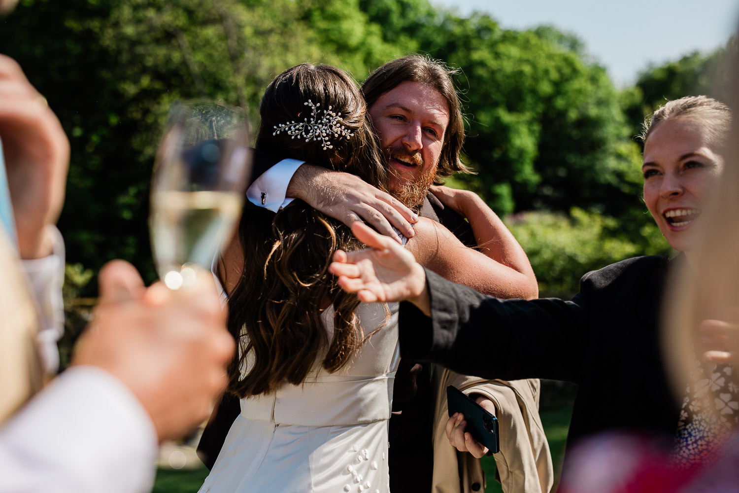 A wedding photographer Devon captures the bride embraces her friend, during the wedding reception.