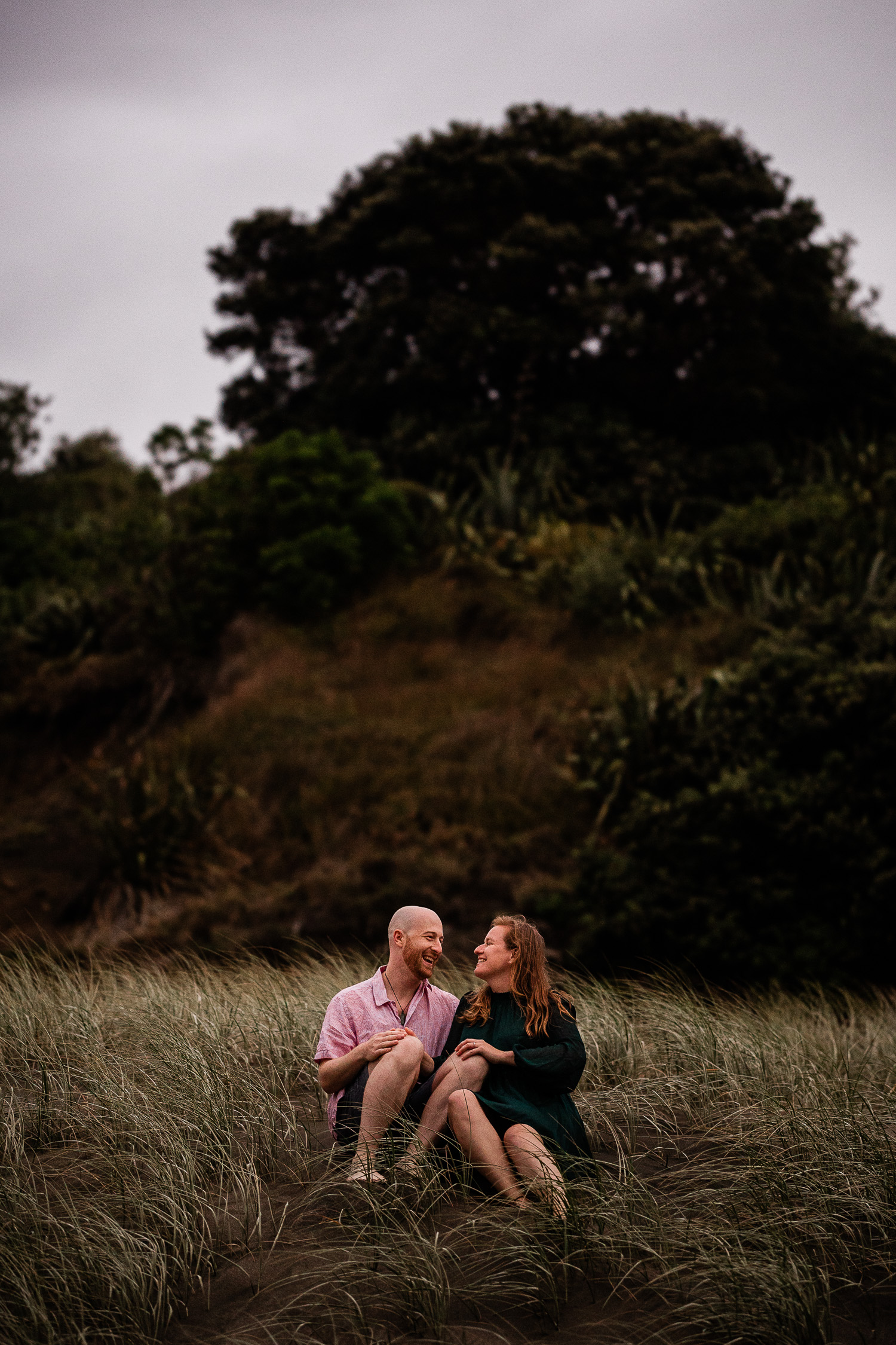 A romantic moment between a couple at Piha beach in New Zealand, during a beach pre-wedding shoot