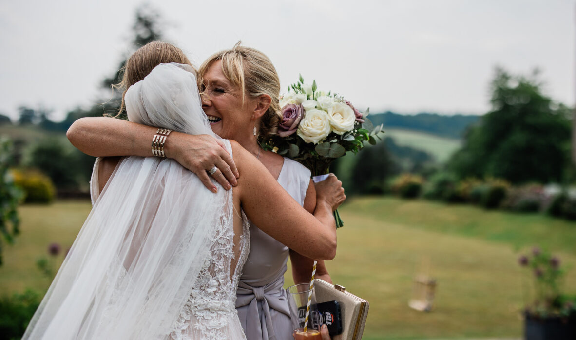 Bride and her mother share a emotional hug, during the wedding reception at Huntsham Court wedding venue in Devon.