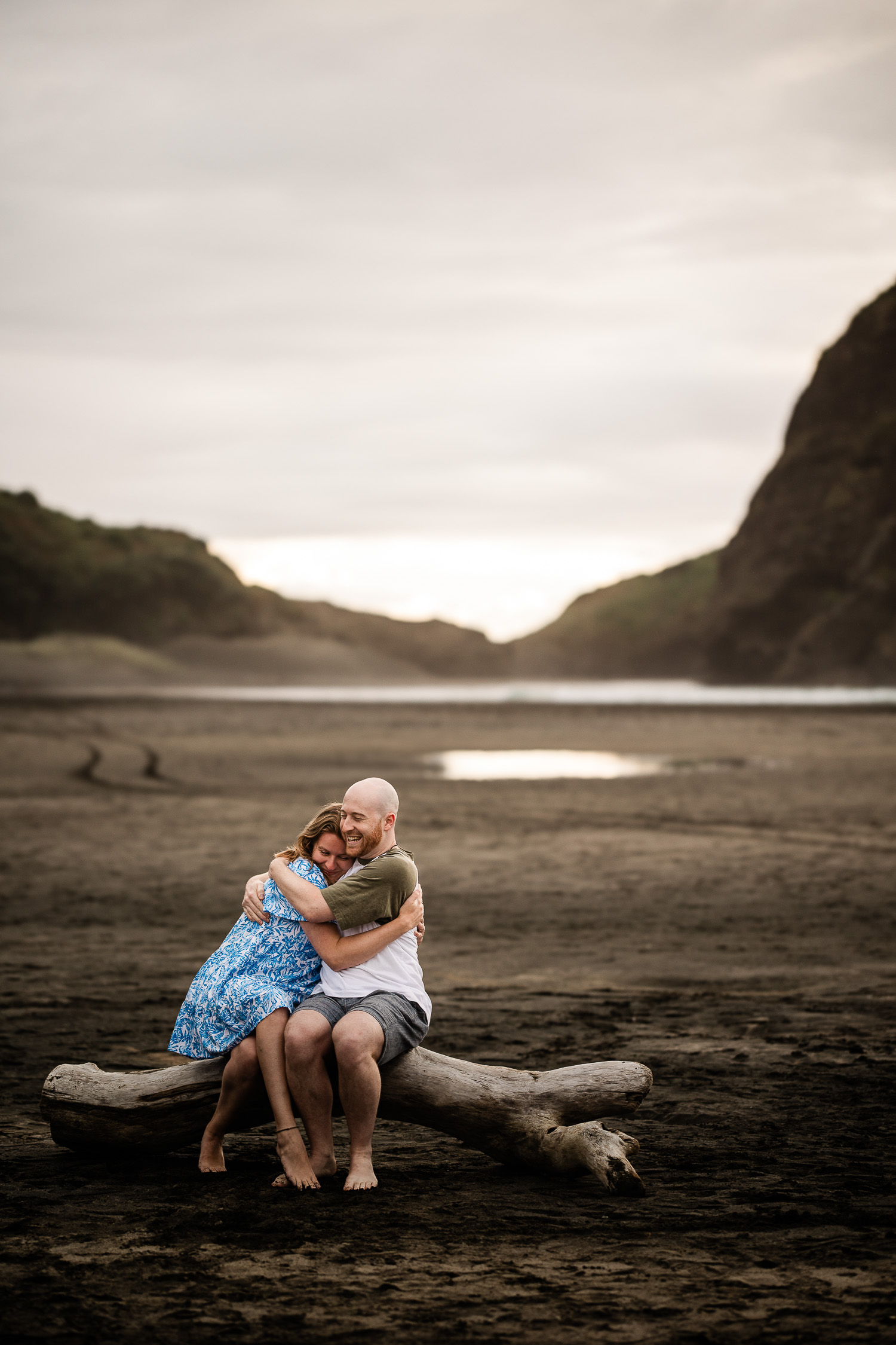 A romantic moment between a an engaged couple, on Piha beach during a documentary pre-wedding shoot